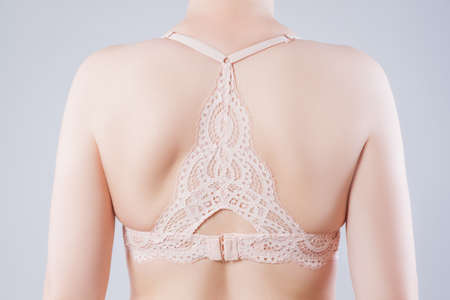 Beautiful female back in a lace bra on gray backgroundの写真素材