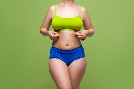 Beauty woman in multicolored underwear on green background, body care concept