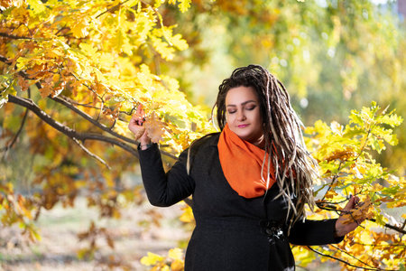 Young happy woman with dreadlocks outdoors in autumn, youth culture concept