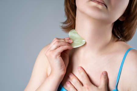 Gouache scraper, facial massage and lifting on gray backgroundの写真素材