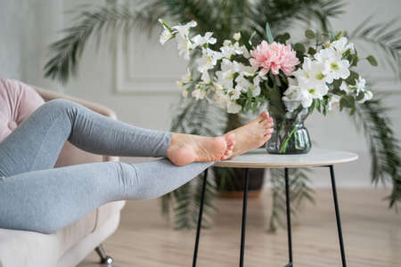 Tired woman resting after work at home, beauty female feet, body care concept, home interiorの写真素材