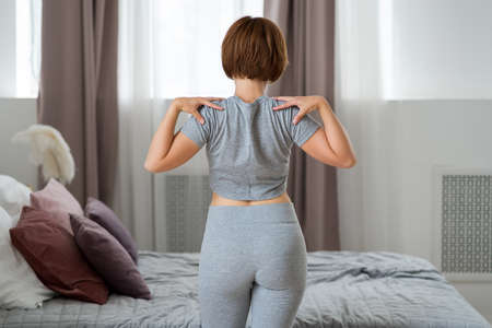 Young woman doing morning exercises in the bedroom, healthy lifestyle conceptの写真素材