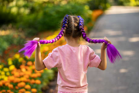 Child with trendy hairstyle, braids with kanekalon on nature backgroundの写真素材