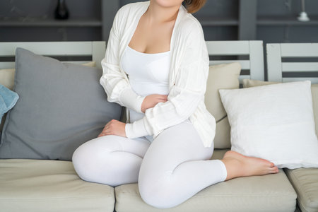 Stomach ache, symptoms of gastritis or pancreatitis, woman with abdominal pain suffering at home, health problems conceptの写真素材
