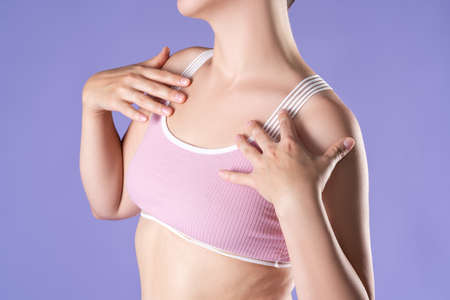 Woman in pink top bra on purple background, body care conceptの写真素材
