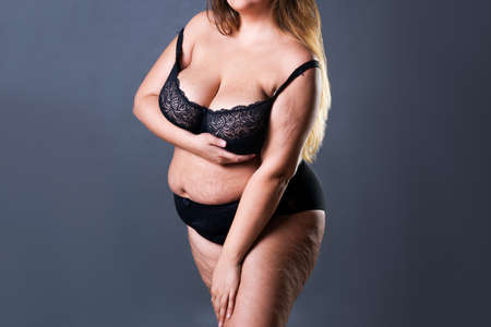 Plus size sexy model in black lingerie, fat woman on gray studio background, overweight female body with stretch marksの写真素材