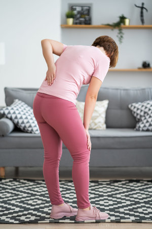 Back pain, kidney inflammation, woman suffering from backache at home, health problems concept