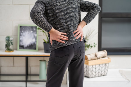 Back pain, kidney inflammation, man suffering from backache at home, health problems concept