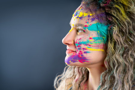 Bodypainting, creative makeup, bright colorful body art on gray studio background, plus size fat woman painted with powder paintsの写真素材