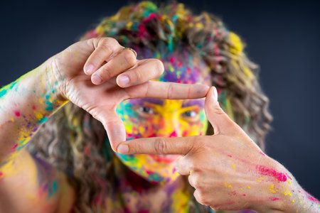 Bodypainting, creative makeup, bright colorful body art on gray studio background, plus size fat woman painted with powder paintsの写真素材
