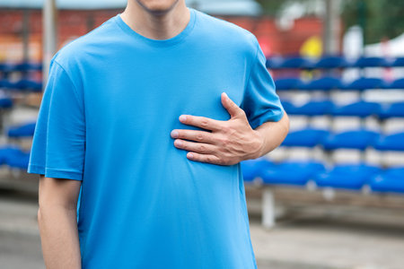 Heart attack, man with chest pain after workout on a sports ground, health problems conceptの写真素材