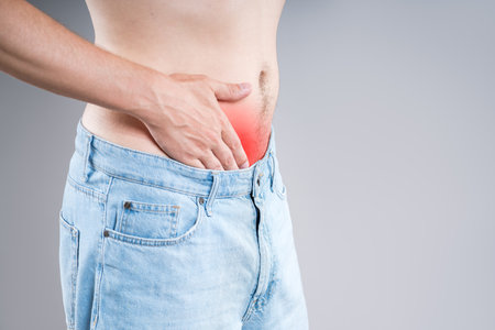 Stomach ulcer, man with abdominal pain on a gray background, symptoms of gastritis, diseases of the digestive system, bladder, pee-pee problem, healthy conceptの写真素材
