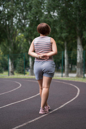 Pain in the hip during training, muscles cramped, backache on a sports ground after workout, health problems conceptの写真素材