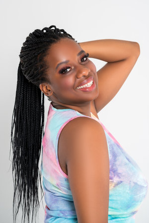 Happy plus size black model in colorful dress, beautiful African woman with curvy figure and pigtailed hairstyle, afro braidsの写真素材