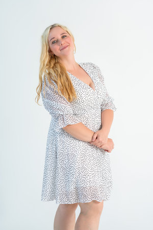 Happy blonde plus size model in polka dot dress, fat woman on gray studio background, body positive conceptの写真素材