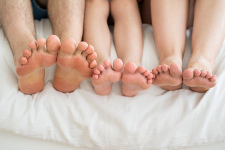 Three barefoot people, mother, father and daughter resting on the sofa, foot closeup, corns and...
