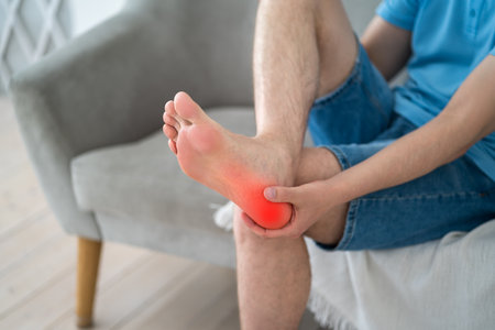 Foot pain, corns and calluses, dry skin on legs, man suffering from feet ache at home, podiatry conceptの写真素材
