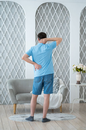 Lumbar and cervical spine hernia, man with back pain at home, compression injury of the...