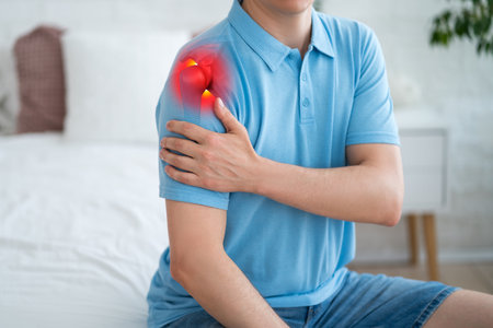 Dislocation of the shoulder, joint inflammation, arthritis and degenerative changes, man with pain in hand at home, health problems conceptの写真素材