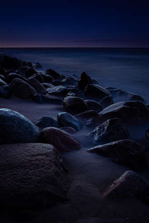 Night by the Baltic Sea with rocks in long exposure techniqueの写真素材