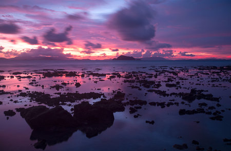 Spectacular sunset over the rocky coast at Nai Yang beach  Phuket island, Thailand