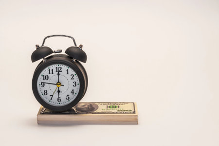 Time is money concept. Alarm clock and dollars on white backgroundの写真素材