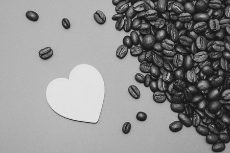 white heart and black coffee beans on a gray backgroundの写真素材