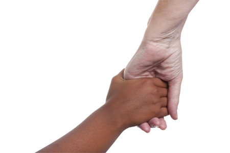 young dark skinned mixed race girls hand holding older fair skinned senior woman's hand. isolated...