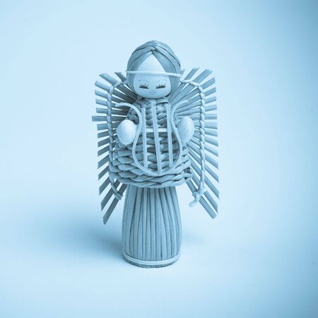 handmade Wicker christmas angel decoration figure, isolated against plain backgroundの写真素材