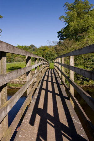 Small wooden bridge accross the river North Tyne in Northumberland near featherstone Castle.