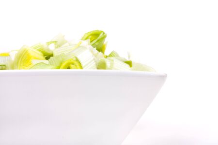 Oriental Salad of chopped leek and celery in attractive white bowl against white background.の写真素材