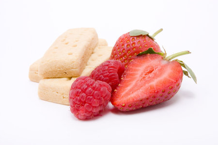 Natural vibrant red Strawberries and Raspberries with shortbread isolated against white background.の写真素材