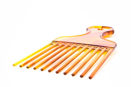 Wide plastic afro comb from low viewpoint isolated against white background.の写真素材
