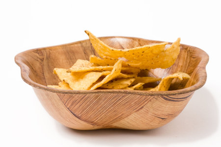 Tortilla Chips or nachos in wooden bowl isolated against white background.の写真素材
