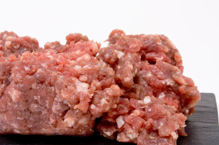 Ground or minced beef from low viewpoint up close against white background.