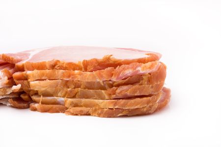 Pile of raw uncooked Sliced bacon isolated against white background from low viewpoint.の写真素材
