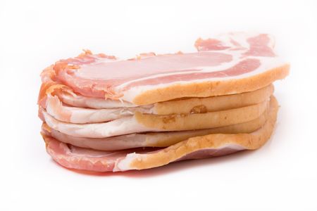 Pile of raw uncooked Sliced bacon isolated against white background from low viewpoint.の写真素材