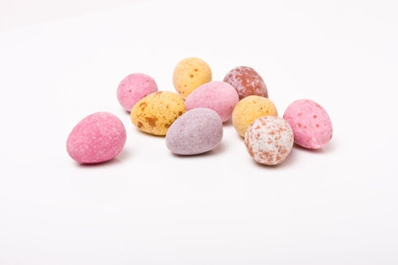 Candy covered small chocolate easter eggs frow low viewpoint against white background.