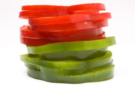 Stack of Sliced Red and Green Peppers arranged on white background.の写真素材