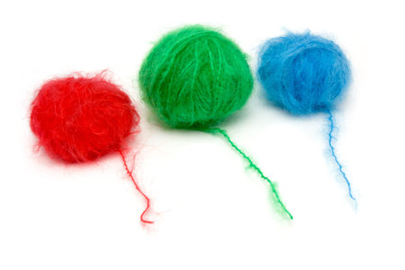 A line up of red, green and blue balls of mohair wool isolated against white background.