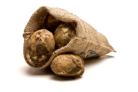 Sack of new Potatoes from low perspective isolated against white background.の写真素材