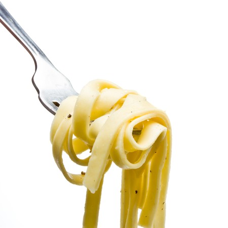 Pasta ribbons tossed in olive oil, salt and pepper on fork isolated against white.の写真素材