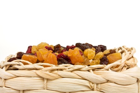 Mixed Dried Fruits of Apricots, sultana, raisins and cranberries in wicker basket.の写真素材