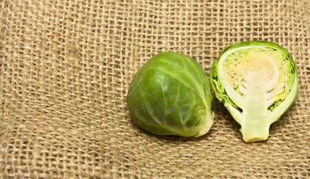 Whole and sliced Brussel Sprout from low perspective on hessian sack background.の写真素材