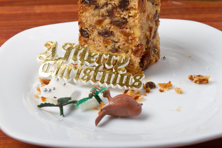 Last piece of christmas cake on plate with crumbs and decorations.の写真素材