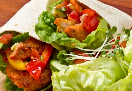 Spicy chicken with salad and salsa wrapped in a soft flour tortilla.の写真素材