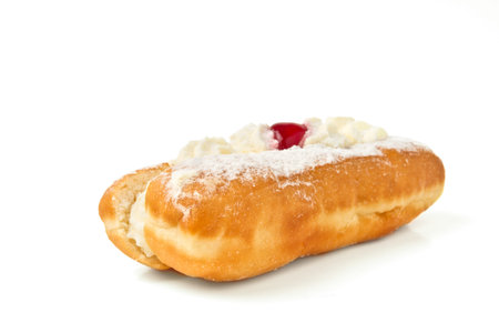 Cream Doughnut decorated with glace cherry isolated on white.