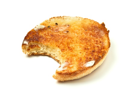 Hot toasted english muffin with butter isolated on white with bite out.の写真素材