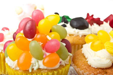 A variety of vibrant fun homemade cup cakes on cake stand.