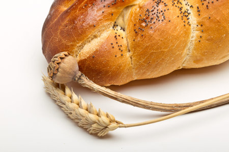 Dried cereal ear and poppy stem with rustic bread concept.の写真素材